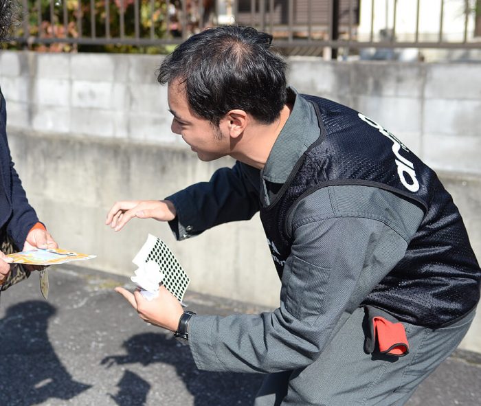 紺色バージョンのメッシュベストを着用された男性スタッフ