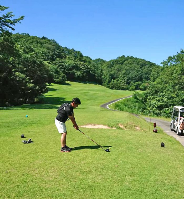 水冷ベストを着てドライバーショットを打つ山脇ゴルフレッスンプロ