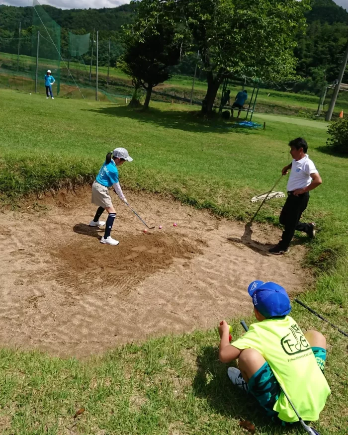 蛍光イエローのオリジナルポロシャツをゴルフ練習中の写真